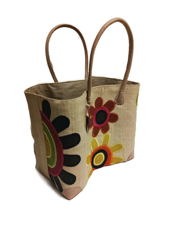 Fairtrade mandtas met bloemen van gevlochten riet met afsluithoes. Fairtrade mandtas met bloemen van gevlochten riet met afsluithoes.